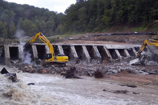 Two excavators hammer away at the Bloede Dam on a river shortly after its breach. Credit: Maryland Department of Natural Resources.