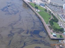 This photo shows an aerial view of Waldenberg Park and skimmers. Oil streamers are a result from the lifting of the damaged barge. Photo credit: USCG