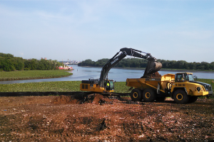 Heavy machinery excavates near where the Delaware River converges with the Cooper River