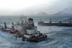 a ship tilts in chippy ocean water with fog in the background